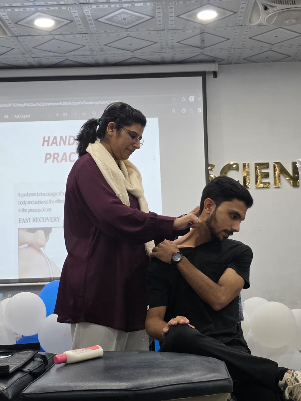Dr. Saima Naseem demonstrating a hands-on cervical technique at a workshop